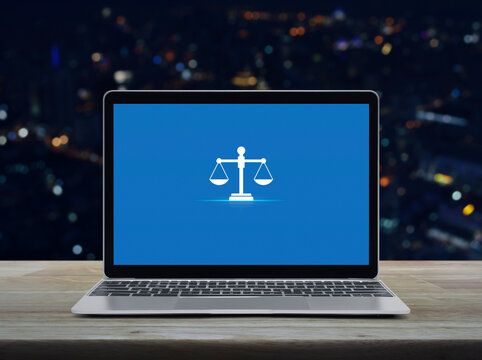 Law flat icon with modern laptop computer on wooden table over blur colorful night light office city tower and skyscraper, Business legal service online concept