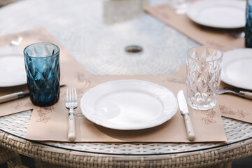 Close up of Served table set at suumer terrace. Cutlery in cafe. Blue glasses