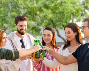friendship and leisure concept - group of happy friends toasting non alcoholic drinks over summer garden background