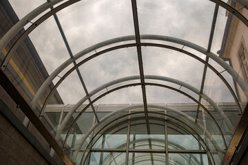 Roof architecture with curved glass for a passageway