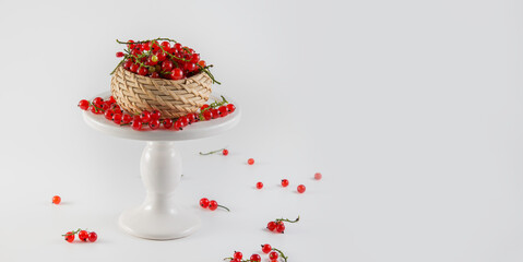 Obraz na płótnie Canvas Ripe tasty bright red currant on a white cake stand on a white background.