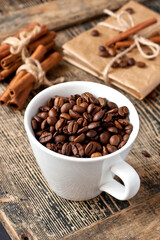 Cup full of coffee beans on wooden table