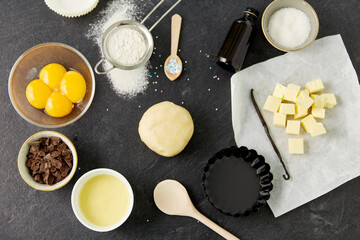 food, culinary and recipe concept - shortcrust pastry dough, baking dish and cooking ingredients on table