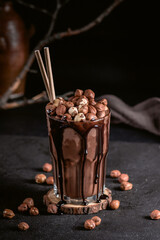 Hot chocolate with hazelnuts on dark background