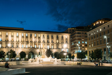 Naples, Italy. Fountain Of Neptune On Piazza Municipio In Evening Or Night Illuminations