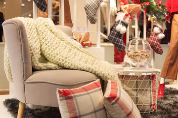Cozy interior room decorated for Christmas. An empty chair with warm plaid.