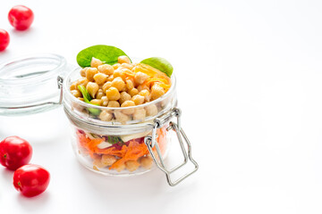 Healthy vegan food. Chickpeas with vegetables in glass jar copy space