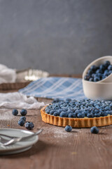 Blueberry tart with fresh berries on wooden background