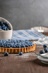 Blueberry tart with fresh berries on wooden background