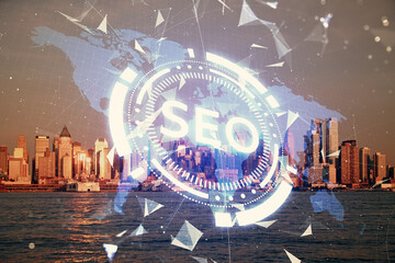 SEO hologram on city view with skyscrapers background double exposure. Search optimization concept.