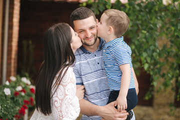Fototapeta premium Happy young family outdoors. Mom with dad and little sun four year old