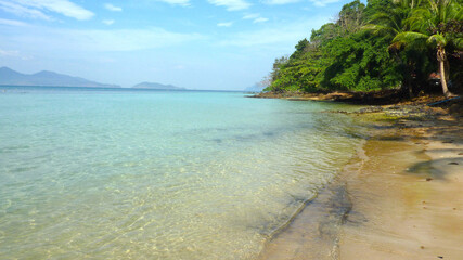 Paradiesischer Strand an Berg mit seichtem blauen Wasser