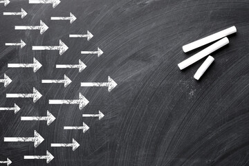 Choose your way. Arrows and pieces of chalk on blackboard, top view