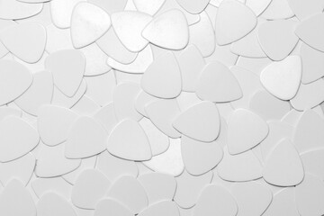 Background on a musical theme from guitar picks of white color