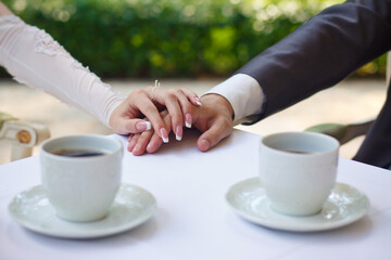 groom embraces the bride with wedding bouquet. rings on the hands of newly-married couple. bride put her hands on the shoulders of the bridegroom.