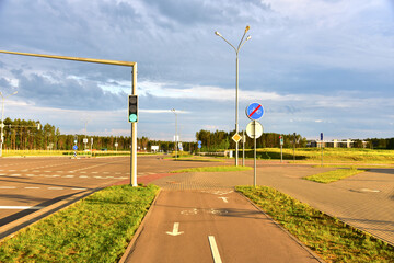 Road sign - the end of cycle path in city at pedestrian zone. Green traffic light signal on a motor road near an intersection and a pedestrian crossing. Roadsafety concept.