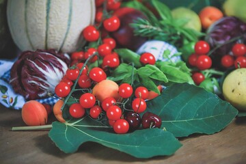 closeup of a bunch of cherry tomatoes and other fruits and vegetables - natural and healthy food concept