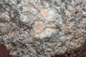 Photograph of a granite surface in soft focus at high magnification. Fine texture of natural mineral of pink color with blurred background. Stone with soft stains of color.