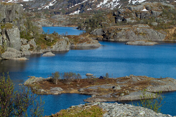 Fototapeta na wymiar Mountain lake with snow on mountains with blue sky