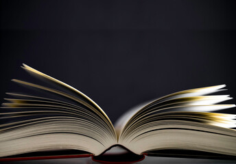 Open book with cover and narrow depth of field on a table with black background