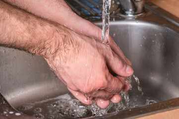 Fototapeta premium Man use soap and washing hands under the water tap