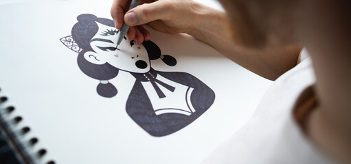 Panoramic shot of artist drawing female character with marker 
