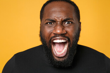Close up of angry irritated african american man football fan in casual black t-shirt isolated on...