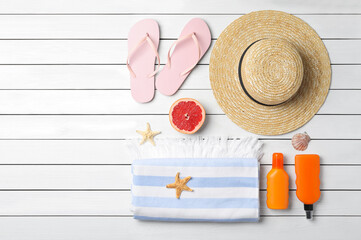 Flat lay composition with grapefruit and beach objects on white wooden background