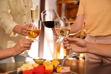 Group of friends toasting with wine at table, closeup