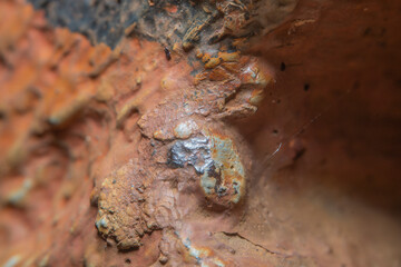 Background with an old metal surface with streaks of rust and peeling paint. Coarse weld seam covered with old paint. Fine details at high magnification. Photo with soft focus and blurred backdrop.
