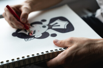 Cropped view of artist drawing sketch of character with pencil