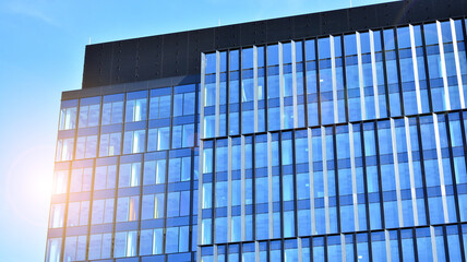 Fototapeta premium Facade texture of a glass mirrored office building. Fragment of the facade. Modern architecture of the office building.