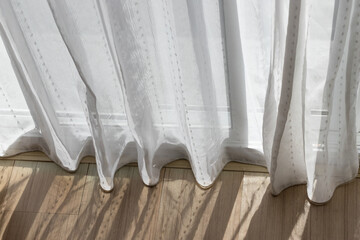 white transparent curtain above wooden floor at glass window. concept : reduce heat from sunlight for saving energy.