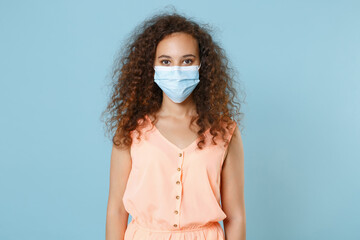 Young african american woman girl in pastel clothes sterile face mask posing isolated on blue...
