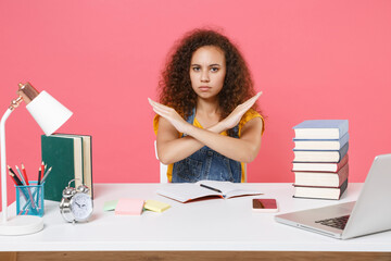 Serious african american girl employee in office isolated on pink wall background. Achievement business career. Education in school university college concept. Showing stop gesture with crossed hands.