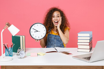 Excited african american girl employee in office work at desk isolated on pink background....