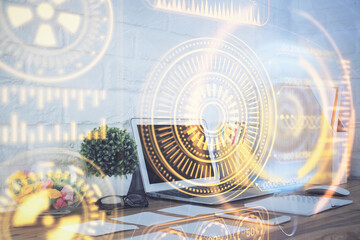 Computer on desktop in office with technology theme hologram. Double exposure. Tech concept.
