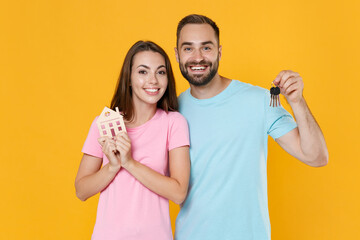 Smiling young couple two friends guy girl in blue pink t-shirts posing isolated on yellow...