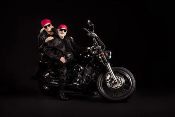 Fototapeta na wymiar Photo of aged bikers grey haired man lady soulmates married couple drive vintage chopper to stars together feel young wear rocker leather jacket pants bandana isolated black color background