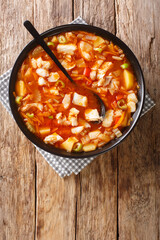 Bermuda fish chowder is a soup that is considered the national dish of Bermuda. Its basic ingredients are fish, tomatoes and onions, seasoned with black rum. Vertical top view