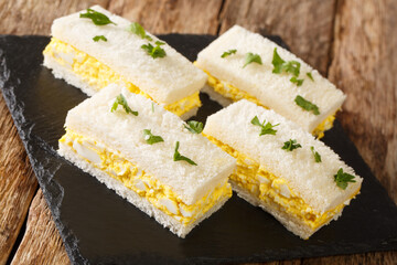 Tamago sando or egg salad sandwiches, are extremely popular in Japan close-up on a slate board on the table. Horizontal