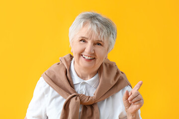 Stylish senior woman on color background