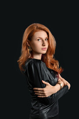 Beautiful young redhead woman on dark background