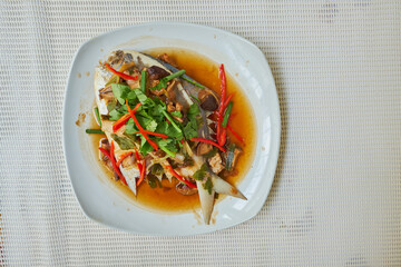 Steamed Butterf fish (SILVER POMFRET)with soy sauce in white dish, top view
