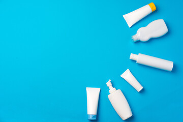 Bottles of sunscreen cream on blue background