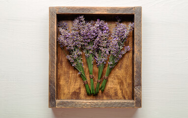 Fresh lavender flower bouquets are dried in wooden box. Bunches of lavender flowers dry. Apothecary herbs for lavender aromatherapy. Top view White background. Rustic provence french style