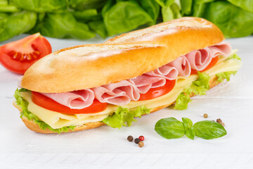 Sub sandwich baguette with ham and cheese on wooden board