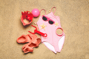 Fototapeta na wymiar Set of beach accessories for children on sand, top view