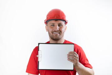 A man in a helmet and a red T-shirt holds an ad in his hands