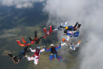 Skydiving. A circle figure of skydivers is in the sky.